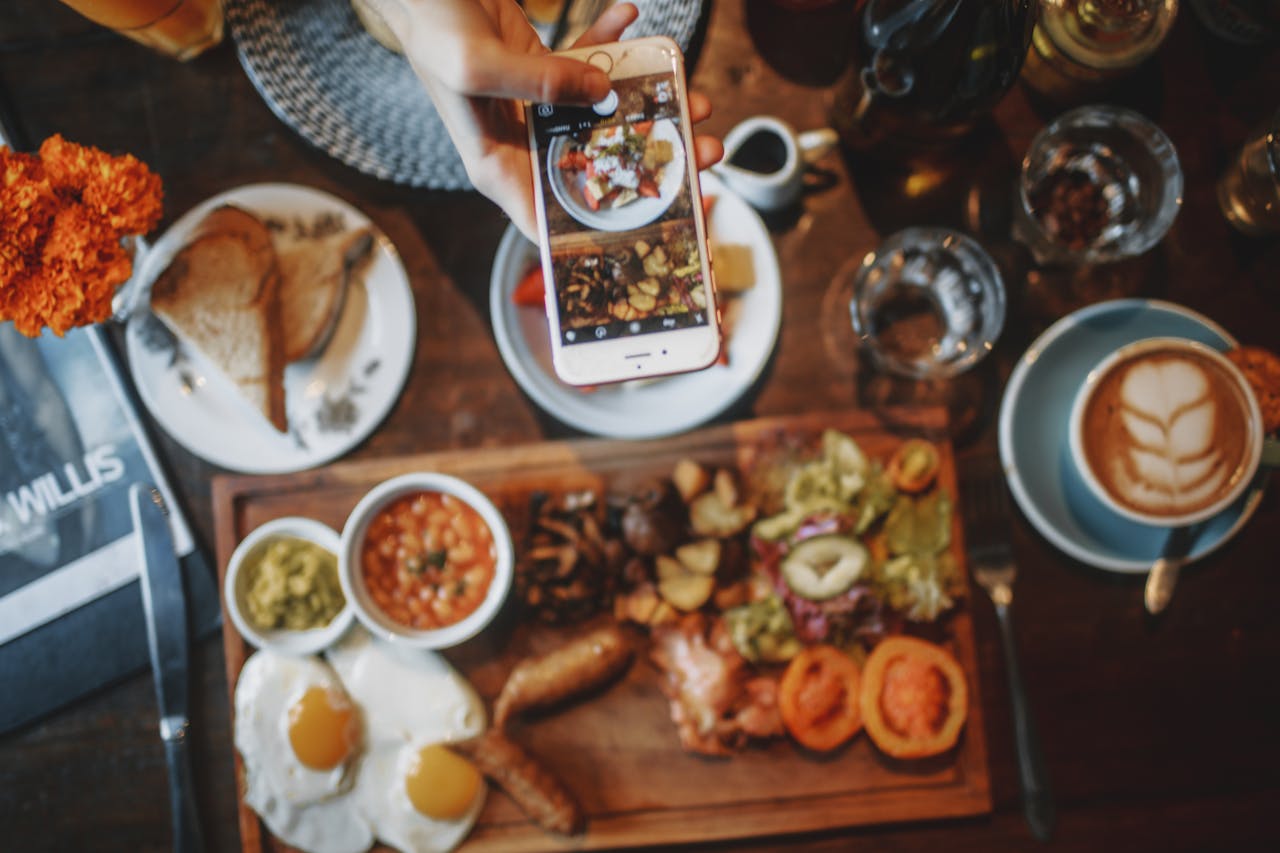 Mastering the First Impression: Your intriguing post title goes here Top view of crop unrecognizable person taking photo of satisfying breakfast and desert with coffee on mobile phone while sitting at table