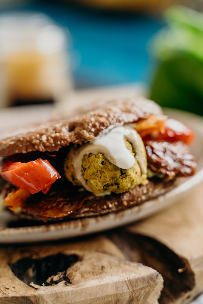 About Delicious vegan falafel sandwich with fresh tomatoes and sauce.