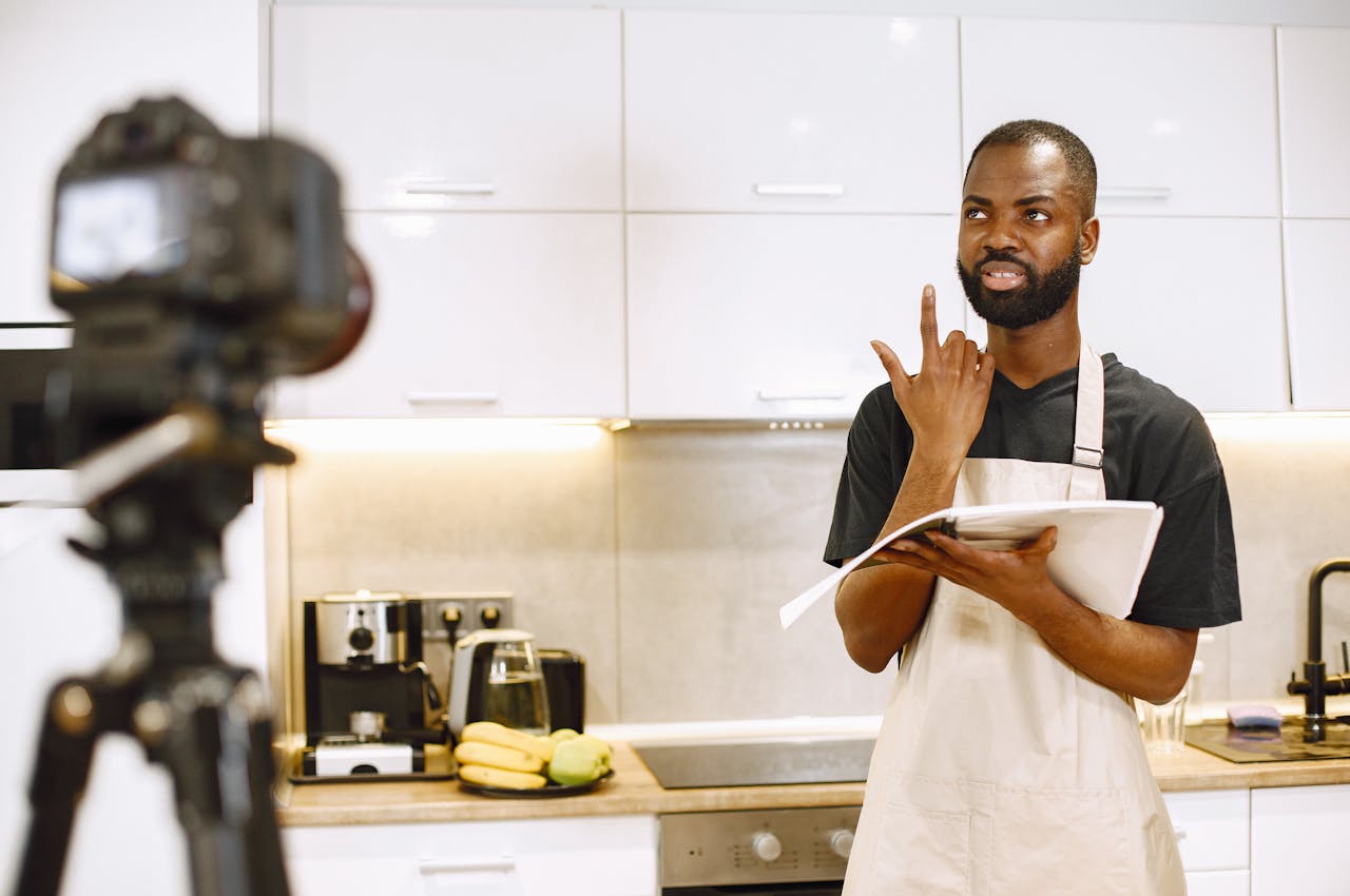 A video blogger records a cooking session in a modern kitchen, sharing recipes.